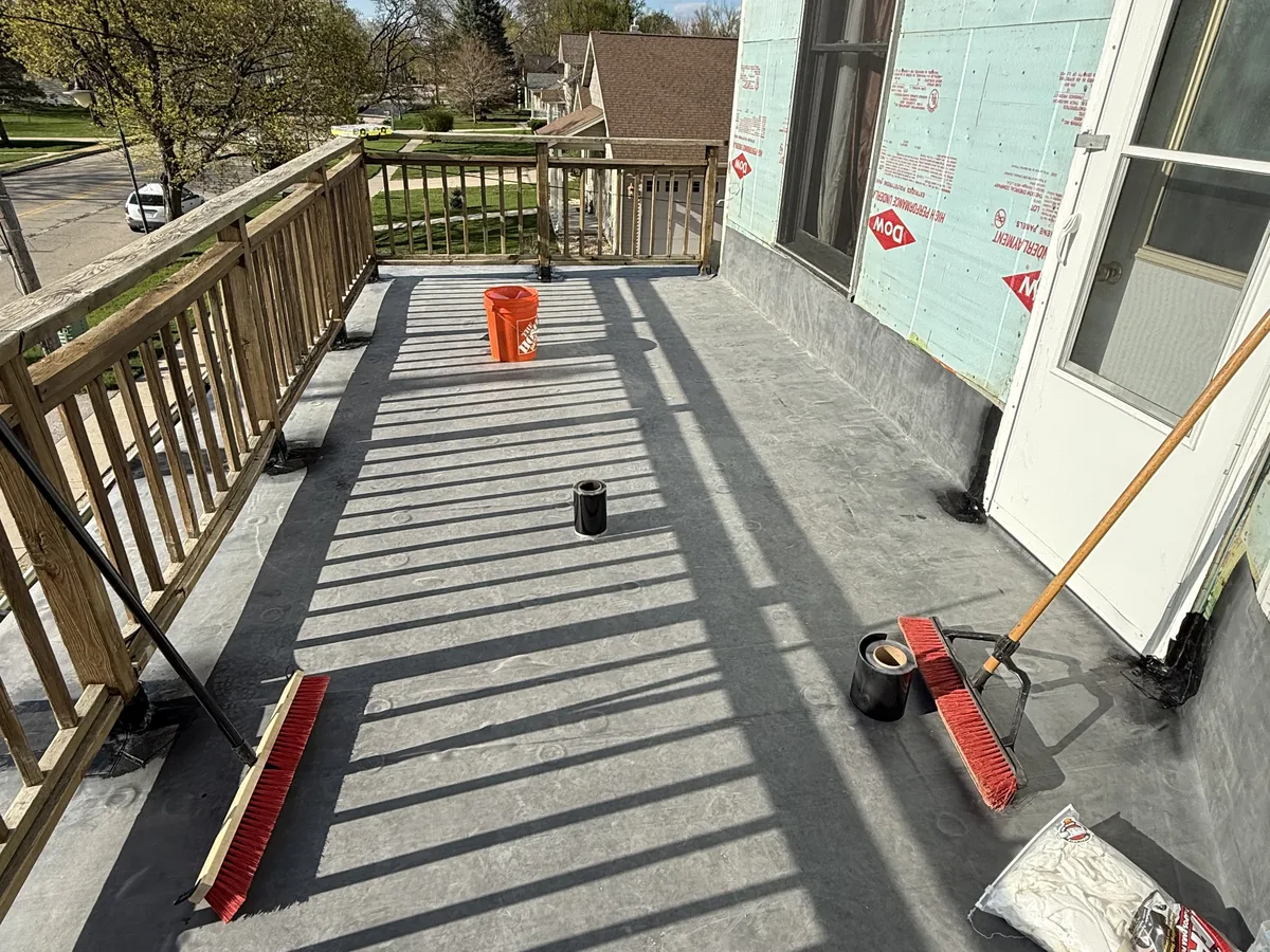 Gray rubber roof membrane rolled out over a deck